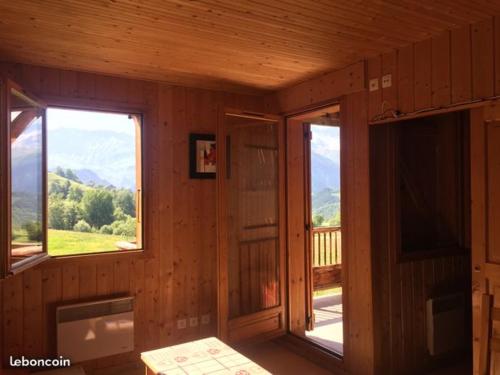 een houten kamer met 2 ramen en een balkon bij Les Marmottes 18 C in La Chal