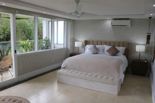 a bedroom with a large white bed and windows at PU4A Big Apt Overlooking Parque Urraca City Center in Panama City