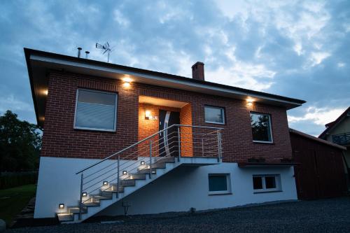 a brick house with a staircase on the side of it at Apartamenty całoroczne "Eleganza" jacuzzi-sauny in Nadole