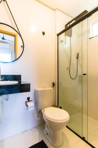 a bathroom with a toilet and a glass shower at Ap do Maro in Barreirinhas