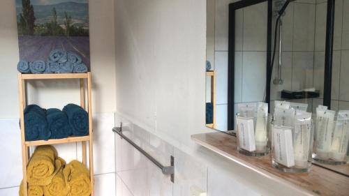 een badkamer met een plank met handdoeken en een spiegel bij Logeren bij de bakker in Schiermonnikoog