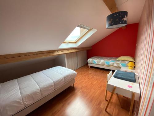 a attic room with two beds and a window at Les brimbelles in Gérardmer