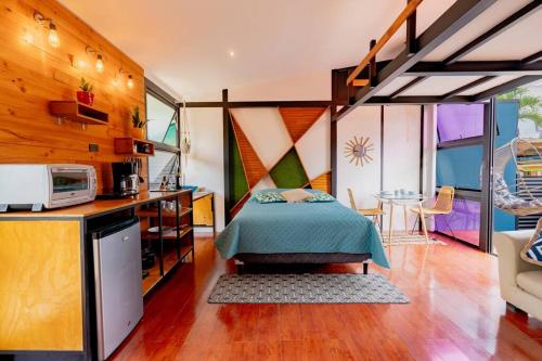 Olly´s House في توريالبا: غرفة نوم بسرير في غرفة مع مطبخ
