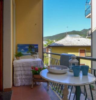 a balcony with a table and a view of a house at Sea La Vie in Moneglia