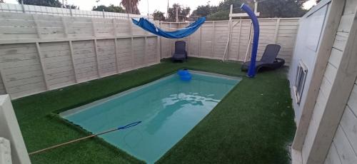 a swimming pool with a hammock in a backyard at באוירה יהודית in H̱azon