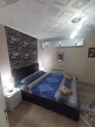 a bedroom with a large bed with a blue comforter at DJERDAN in Vranje
