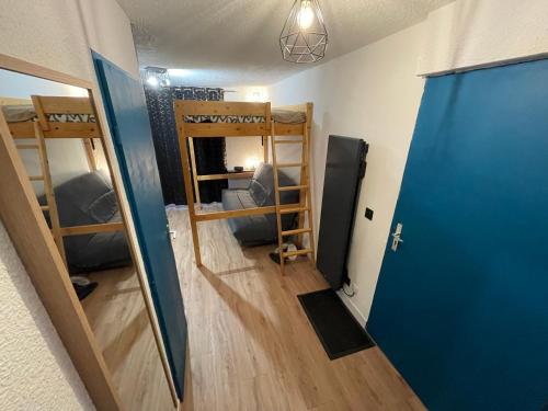 a room with two bunk beds and a blue door at Magnifique Studio Vieil Alpe Huez 4 pers. - HUEZ in LʼHuez