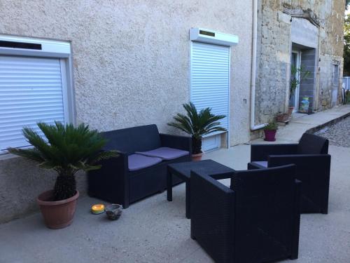 a patio with a couch and tables and plants at Chez Lofred 2 in Four