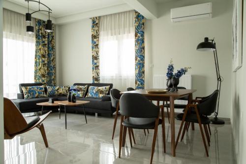 a living room with a table and chairs and a couch at City Chic Apartment in Volos