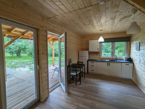 a kitchen and dining room of a tiny house with a porch at Osada Karszewo, sauna bania, ryby in Karszewo