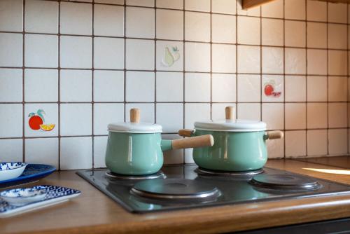 two pots on a stove top in a kitchen at To Pyrgaki Kos in Kos Town