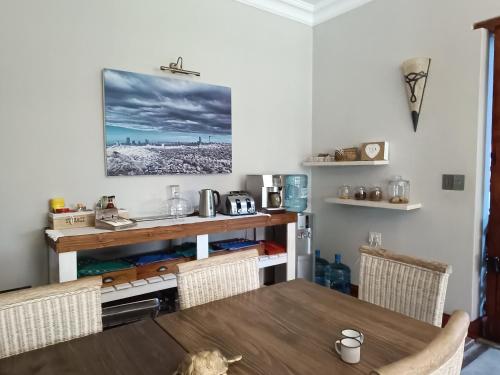 a dining room with a wooden table and chairs at Ikamu's lodge in Germiston