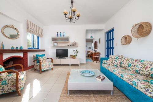 a living room with a blue couch and a table at To Pyrgaki Kos in Kos