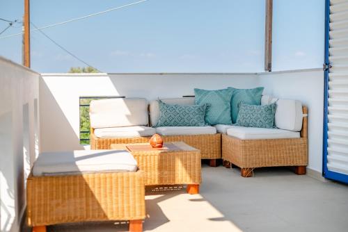 a patio with a couch and wicker chairs at To Pyrgaki Kos in Kos Town