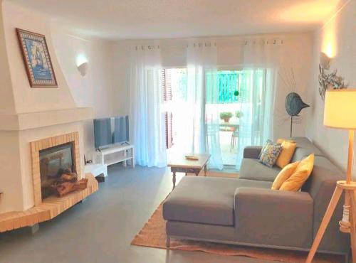 sala de estar con sofá y chimenea en Seaside SunFlower, en Quinta do Lago
