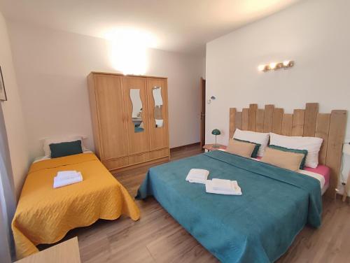une chambre avec deux lits avec des serviettes dessus dans l'établissement T3 de 140m2 pour 7 pers- Extra centre Ajaccio - À 5 min à pied des plages - Classé 5 étoiles - CASA DI ARTISTI, à Ajaccio