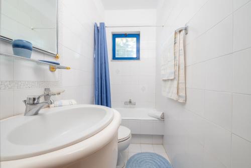 bagno bianco con servizi igienici e lavandino di To Pyrgaki Kos a Città di Kos