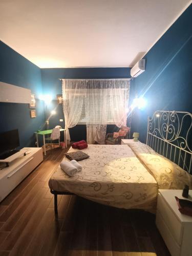 a bedroom with a large bed and a blue wall at Colombo Holidays APT in Rome