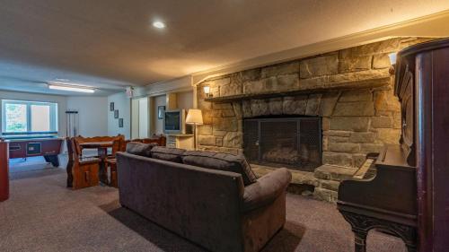 a living room with a couch and a stone fireplace at 4 Seasons at Beech Mountain in Beech Mountain