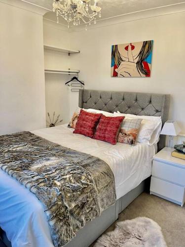 1 dormitorio con 1 cama grande con almohadas rojas en The Princes Dartford Stunning Entire Space, en Kent