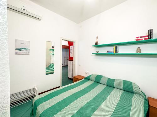 una camera con un letto a righe verde e bianco di Casa Quarti a Rimini