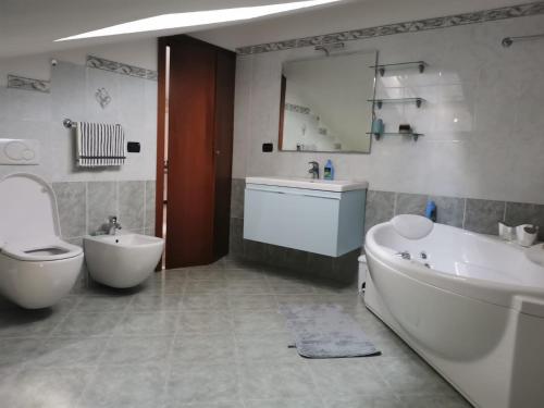 een badkamer met een bad, een toilet en een wastafel bij Serenity Home in Posta Vecchia