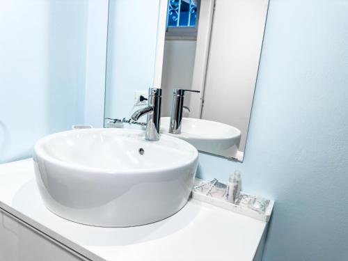 een witte badkamer met een wastafel en een spiegel bij Casa Quarti in Rimini