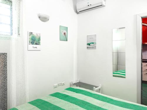 a white room with a bed and a mirror at Casa Quarti in Rimini