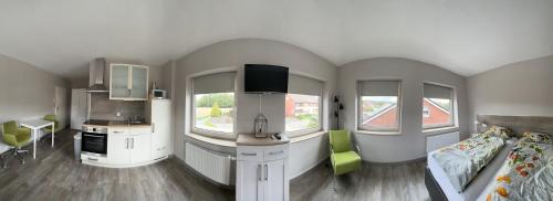 a living room with a bed and a kitchen with windows at Haus Wijnen in Bad Bentheim