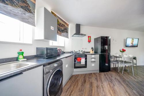 a kitchen with a washer and a sink and a dishwasher at *F1BR* for your most relaxed & Cosy stay + Free Parking + Free Fast WiFi in Batley