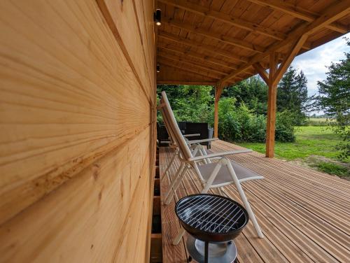 a wooden deck with a chair and a desk on it at Osada Karszewo, sauna bania, ryby in Karszewo