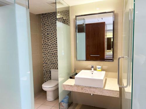 ein Badezimmer mit einem Waschbecken, einem WC und einem Spiegel in der Unterkunft Infini Suites@ D'Majestic Place Kuala Lumpur in Kuala Lumpur