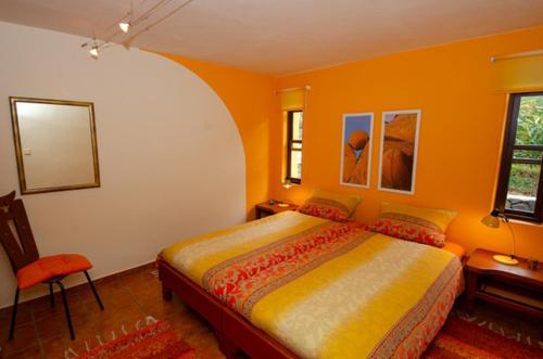Jedey的住宿－Estrella - Finca Manana，橙色客房内的一间卧室,配有一张床