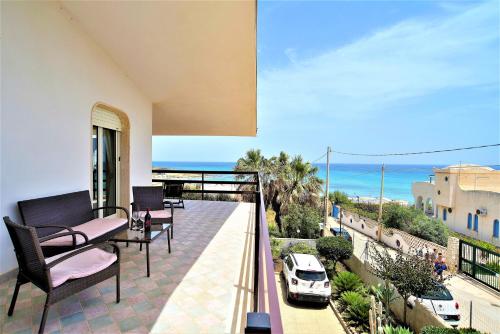 a balcony with chairs and a view of a car at Tra Cielo e Mare - Spiaggia San Lorenzo in Reitani