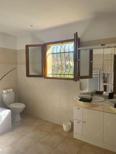 une salle de bain avec toilettes, lavabo et fenêtre dans l'établissement Quillan Villa with Pool, à Quillan