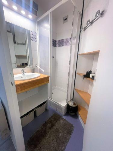 une salle de bain blanche avec une douche et un lavabo dans l'établissement Appartement avec piscine en Vallée d’Ossau, à Bielle