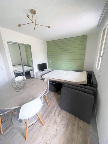 une petite pièce avec un lit et une table dans l'établissement Appartement avec piscine en Vallée d’Ossau, à Bielle