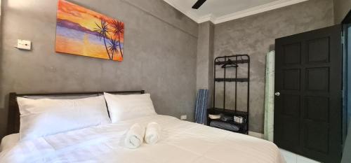 ein Schlafzimmer mit einem Bett mit zwei weißen Schuhen darauf in der Unterkunft Sunset view,Ground Floor to BEACH, 1-5pax in Port Dickson