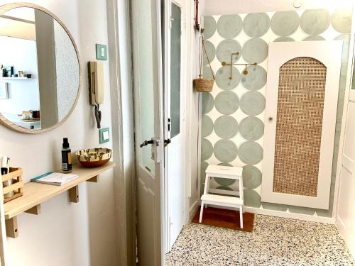 a bathroom with a mirror and a small stool at Casa Mafalda trilocale in centro in Biella