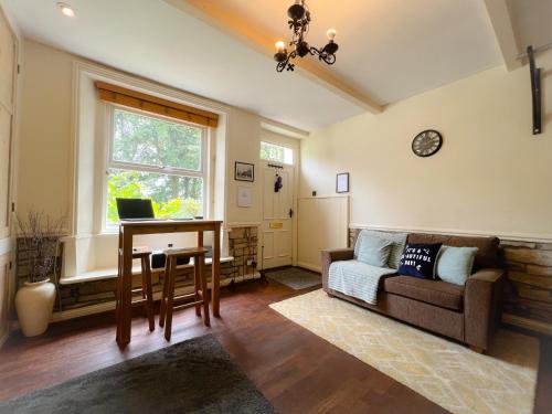 a living room with a couch and a table with a laptop at Rural Yorkshire Getaway - Modern Victorian Cottage, Long term stay offers, message direct in Luddenden Foot