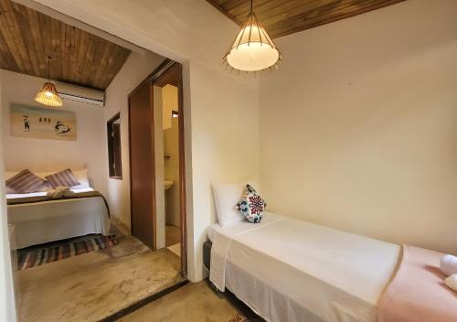 a small room with a bed and a bedroom at Pousada Raiz Forte in Caraíva