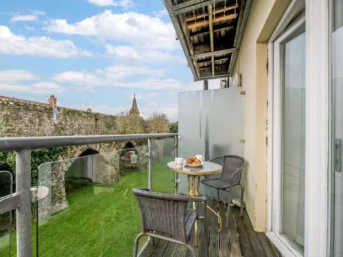 a patio with a table and chairs on a balcony at The beautifully central Flat 3 The Cobourg Tenby Sat to Sat booking only in school summer holidays in Pembrokeshire