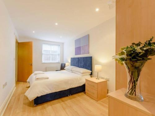 a bedroom with a bed and a vase of flowers at The beautifully central Flat 3 The Cobourg Tenby in Pembrokeshire