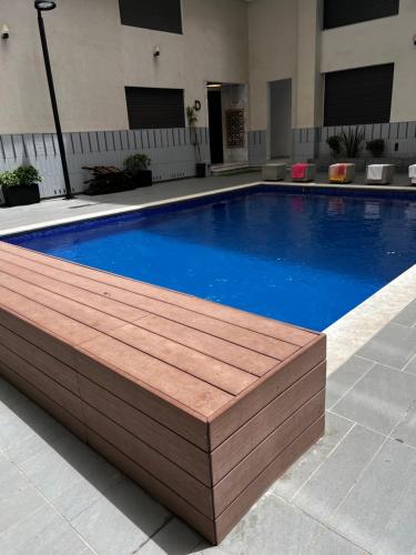 a large swimming pool with a wooden deck around it at Duplex moderne à 1 minute à pied de la plage- Résidence Miramar Mohammedia in Mohammedia