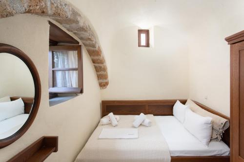 a small room with a bed and a mirror at Bastione Malvasia Hotel (ex New Malvasia) in Monemvasia