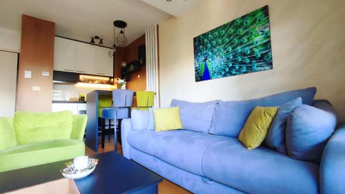 a living room with a blue couch and a table at BalkanHill2 S37 Pekovic green in Zlatibor