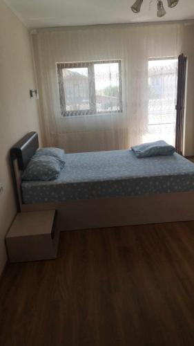 a bedroom with a bed with blue sheets and a window at Casa Loredana in Mangalia