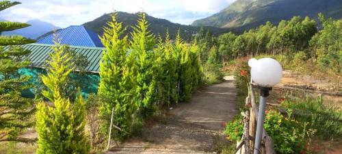 a path in a garden with trees and a building at Moon Valley, kanthalloor in Kanthalloor