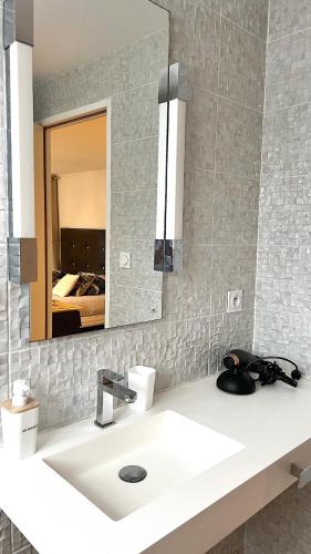 une salle de bain avec un lavabo et un miroir dans l'établissement Suite Junior Layon - Maison Bossoreil, à Angers
