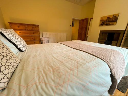 a bedroom with a bed with a blanket on it at Rural Yorkshire Getaway - Modern Victorian Cottage, Long term stay offers, message direct in Luddenden Foot